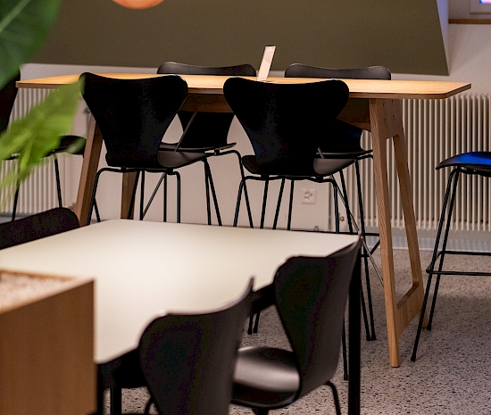 Kantine Loeb: Tische Alpha von Embru Spezialanfertigungen mit schwarzer Kante und schwarzem Untergestell, Stühle und Barhocker ohne Armlehne aus der Serie 7 von Fritz Hansen, Stehtische Desk von Vifian in Eiche, Lampen von &tradition, Modell Flowerpot VP7 und VP1